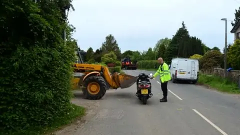 Lancashire Police JCB shown coming out and the motorbike it hit