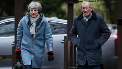 PA Theresa May and her husband Philip arrive for a church service on Sunday