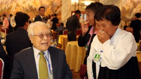 EPA 101-year-old Paek Seong-gyu (L) smiles as he meets his granddaughter Baek Yong-ok (R)