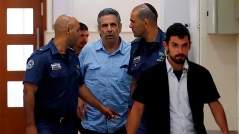 AFP File photo showing Gonen Segev being led into court in Jerusalem on 5 July 2018