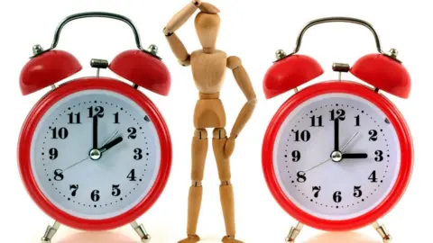 Getty Images A mannequin looks puzzled beside two clocks