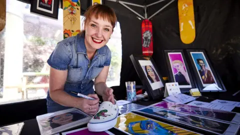 Mark Waugh woman customising shoe at We Invented The Weekend on Saturday