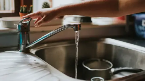 Getty Images Someone turning on a tap