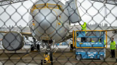 Getty Images Workers inspect a Boeing 737 MAX aircraft owned by American Airlines