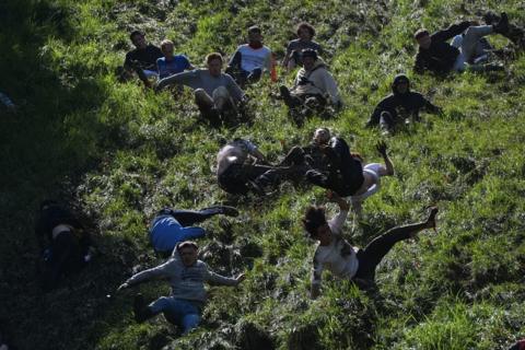 Cheese rolling contestants tumble down Cooper's Hill in Gloucestershire