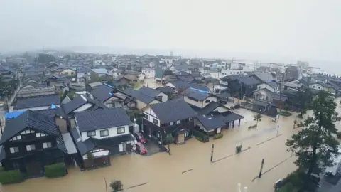 AP An aerial photo showing brown flood water covering roads in the region of Ishikawa