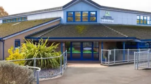 The outside of a primary school, with blue painted windows