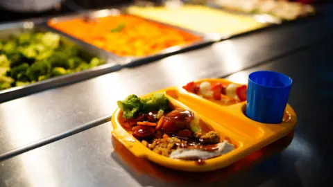 PA Media A tray on a school canteen filled with food and a cup of juice