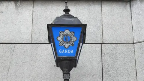 Getty Images A blue and black Garda light sits on a grey stone wall