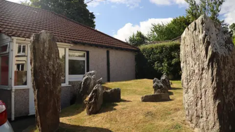 Two large standing stones, split down the middle, leaving a large gap between them 