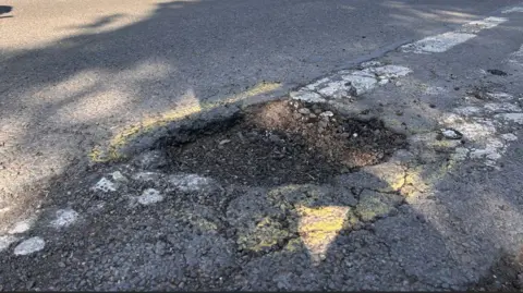 Image of a pothole with a yellow ring of paint around it