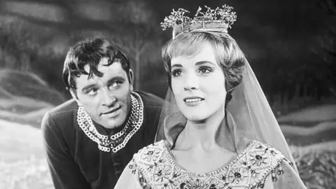 Getty Images Uma foto em preto e branco de Julie Andrews interpretando a rainha Guinevere e Richard Burton interpretando o rei Arthur no musical da Broadway, Camelot, em Nova York, em 1960. 