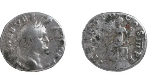 Andrew Williams/Norfolk County Council The front and back of a silver Roman coins. Emperor Vespasian, in profile and facing him is the back of the coin showing the seated goddess Pax. It dates to AD70 to 2.