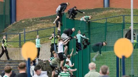 SNS Fans climbing fence outside Hampden