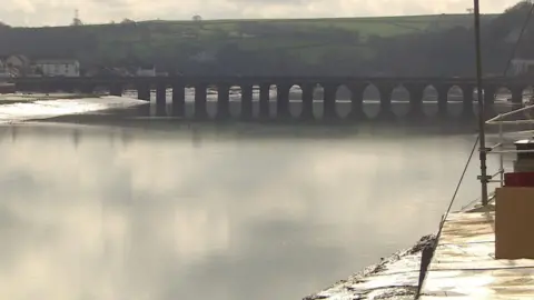 Bideford Port on the River Torridge with still water and a bridge in the background