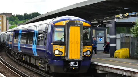 Southeastern A dark blue Southeastern Class 377 train at a station platform