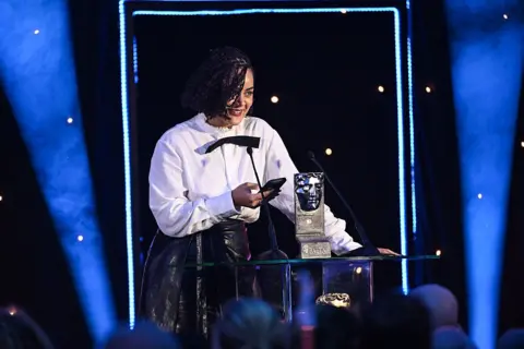 Getty Images A woman picking up an award
