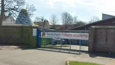 Google A school gate with the words Feversham Primary Academy written on a white banner across the gates