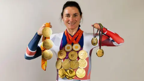 Dame Sarah Storey posing with her gold medals