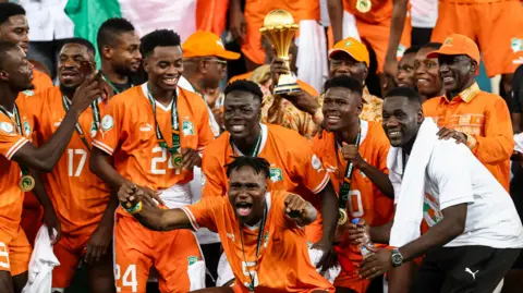 Ivory Coast coach Emerse Fae (far right) celebrates with his players after winning the 2023 Africa Cup of Nations on home soil