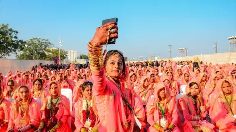 AFP A Muslim bride takes a selfie with her mobile phone as she participates in an 'All Religion Mass Wedding' ceremony at Sabarmati Riverfront in Ahmedabad on February 8, 2020. (P