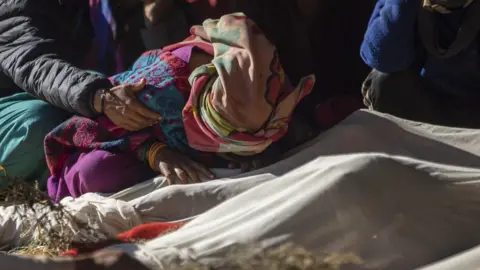EPA A relative mourns over bodies of victims during cremation procession at Chiuri village in Jajarkot, Nepal, 05 November 2023.