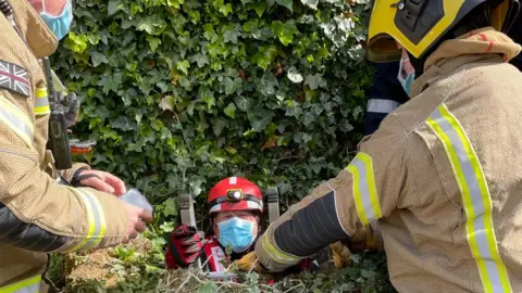 Northamptonshire Fire and Rescue Service Firefighter coming out a well