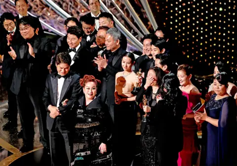 Reuters The cast and crew of Parasite accept their Oscar for best picture