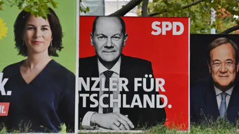 Getty Images Billboards with election campaign posters showing the three chancellor candidates: co-leader of Germany's Greens (Die Gruenen) Annalena Baerbock; German Finance Minister and Vice-Chancellor of the Social Democratic SPD Party Olaf Scholz; and Christian Democratic Union CDU leader Armin Laschet