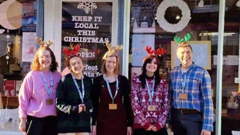 Suddenly on Sheaf Street Five people wearing lanyards and standing outside a bookshop