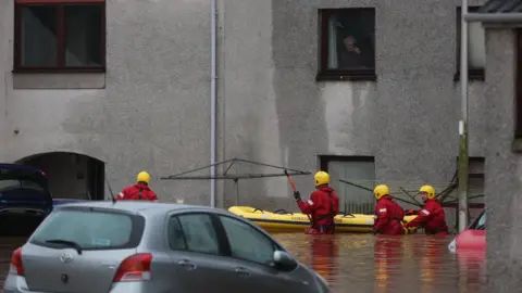 Reuters Emergency services assist in the evacuation of people from their homes in Brechin.