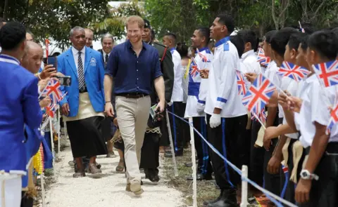 Getty Images Prince Harry, Duke of Sussex, is greeted by students during a visit to Tupou College in Tonga on 26 October 2018