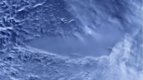 Science Photo Library Satellite image of a flat region of ice, surrounded by more textured terrain