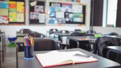 Getty Images Desks in a classroom