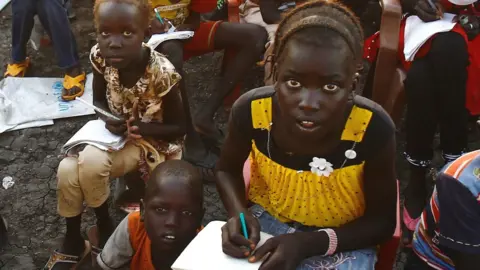 Getty Images South Sudanese refugees take reading lessons at the UNHCR camp of al-Algaya in Sudan's White Nile state, south of Khartoum, 17 May 2017