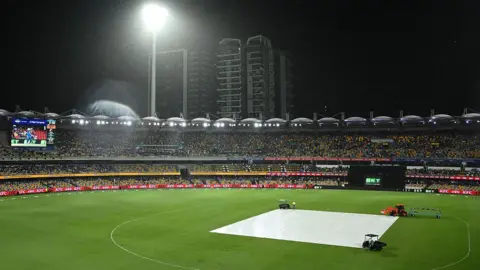A general view of the Gabba in the rain with the covers on