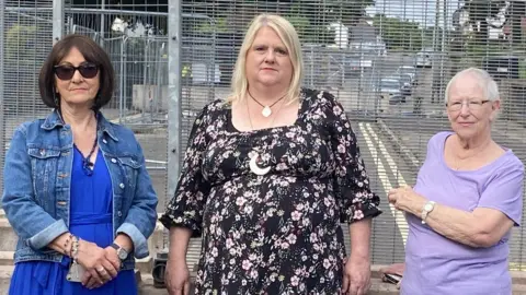 Residents stood outside the gates blocking access to the bridge