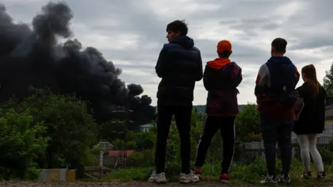 Reuters Teenagers look at smoke which rises after a Russian missile strike
