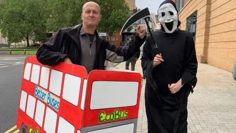BBC Protester Richard Teasdale pictured in a makeshift bus made from cardboard