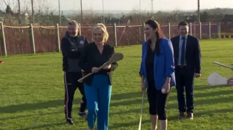 Michelle O'Neill and Emma Little-Pengelly at St Paul's GAC (Gaelic Athletic Club) in west Belfast