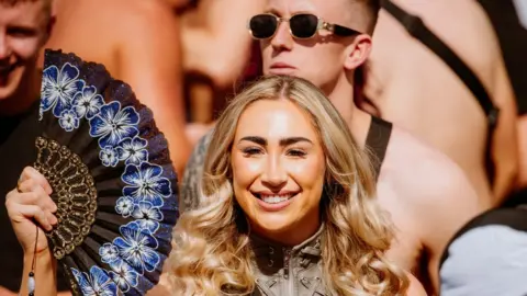 ALASTAIR BROOKES A young woman with blonde hair fans herself at Love Saves The Day in Bristol