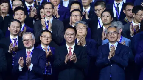 Getty Images Evergrande Group Chairman Xu Jiayin (C) attends Evergrande New Energy Auto Global Strategic Partners Summit on November 12, 2019 in Guangzhou, Guangdong Province of China.