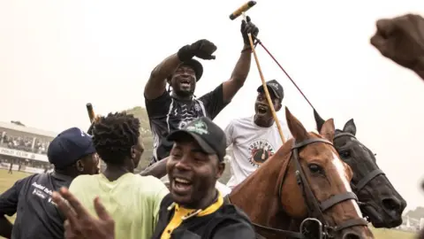 AFP Stablemen and a player celebrate on the field as their team wins the final of the Lagos International Polo Tournament in Lagos on February 19, 2023