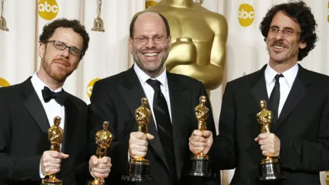 Getty Images Scott Rudin with Ethan and Joel Cohen at the Oscars in 2008