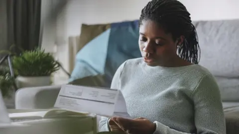 Getty Images Woman looking at an energy bill