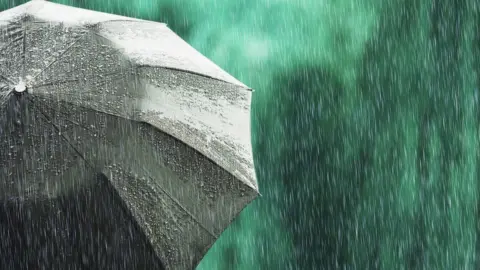 Getty Images Open black umbrella in wet weather