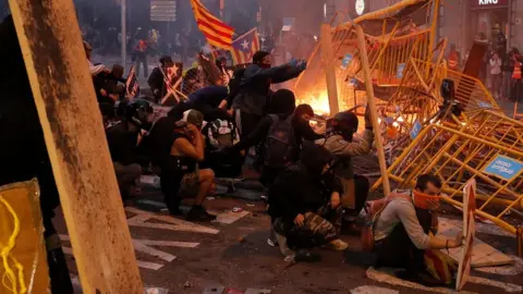 AFP Protesters use fences as a barricade during clashes near police headquarters in Barcelona, on October 18, 2019