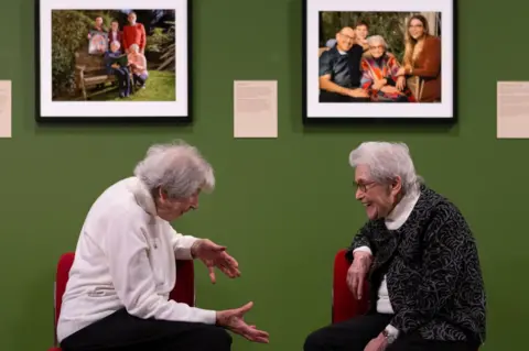 EPA Holocaust survivors Marianne Philipps (L) and Anne Super (R) sit beneath portraits of themselves