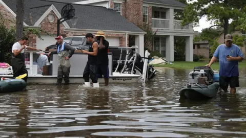 Getty Images People use boats to help bring items out of homes on September 3, 2017 in Houston, Texas.