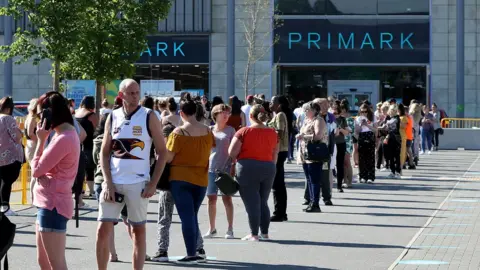 Getty Images Shoppers queued outside Primark when it reopened on 15 June